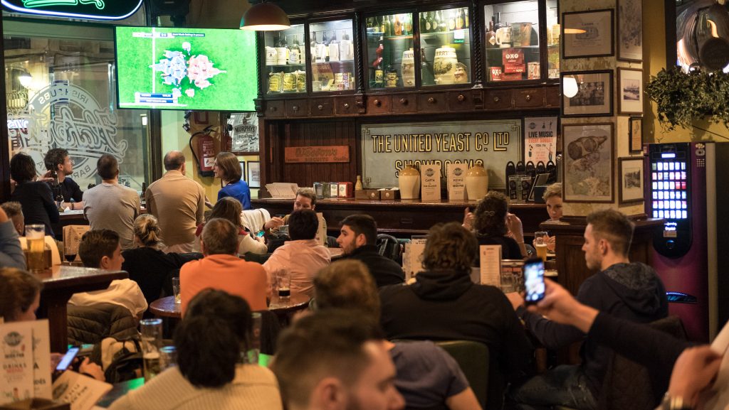 Aficionados viendo fútbol en pub