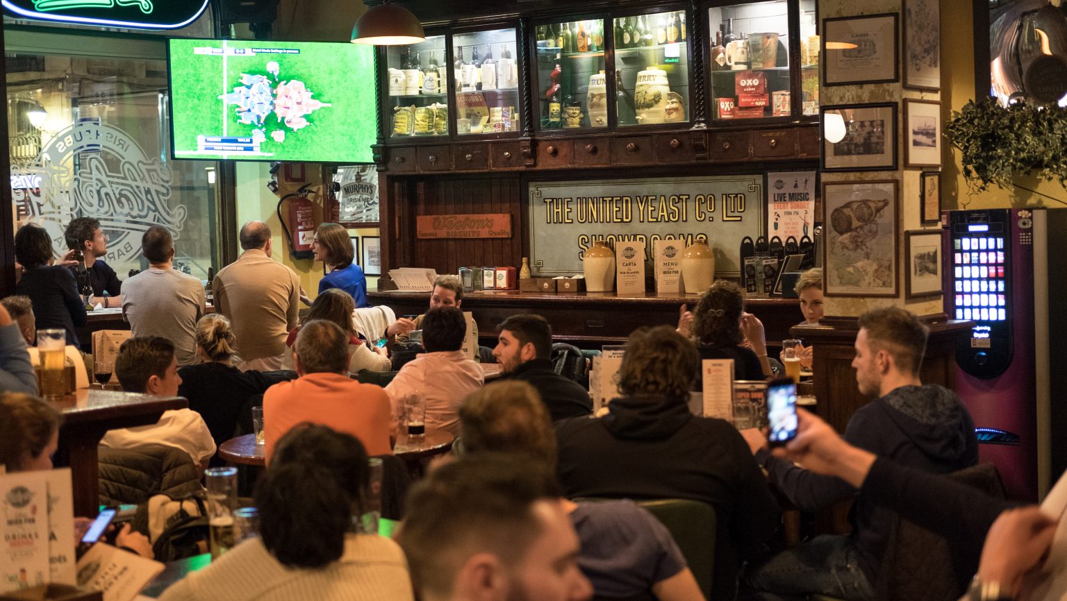 Aficionados viendo fútbol en pub