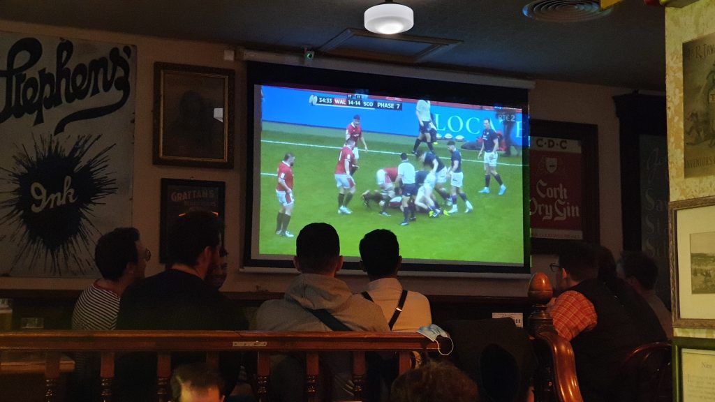 Clientes disfrutando de partido en proyector